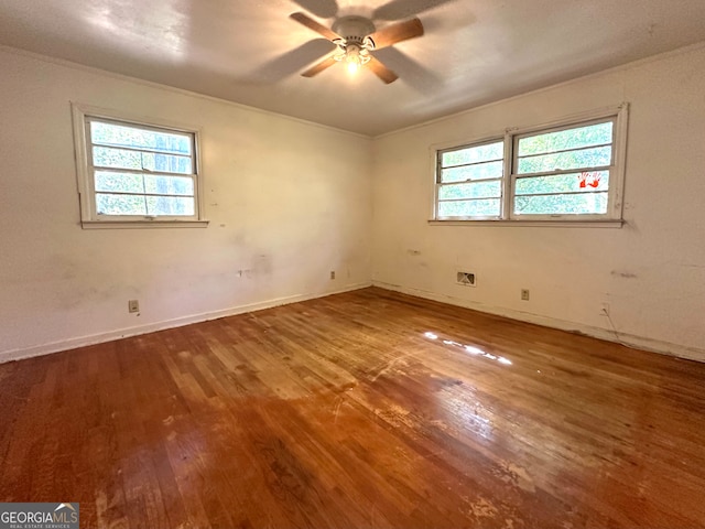 unfurnished room with a wealth of natural light, crown molding, hardwood / wood-style flooring, and ceiling fan