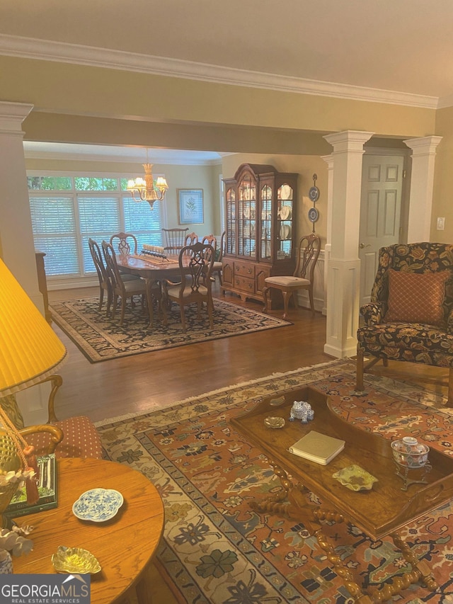 dining space featuring wood-type flooring, ornamental molding, and ornate columns