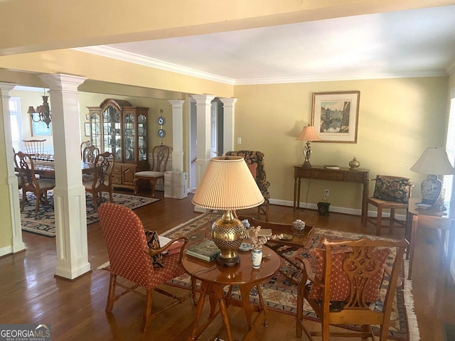 living area with crown molding, dark hardwood / wood-style flooring, and ornate columns