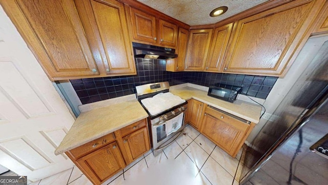 kitchen with light tile patterned flooring, stainless steel range with electric stovetop, a textured ceiling, and tasteful backsplash