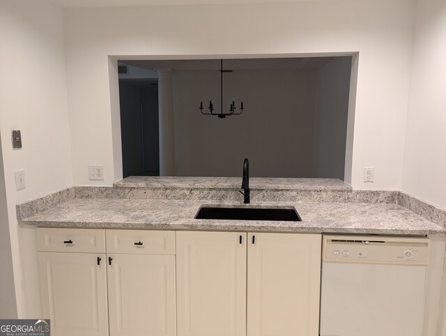 kitchen with white cabinetry, light stone countertops, dishwasher, and sink