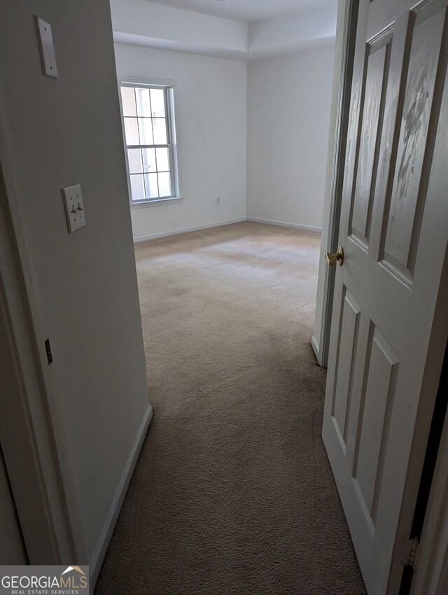 hall with light colored carpet