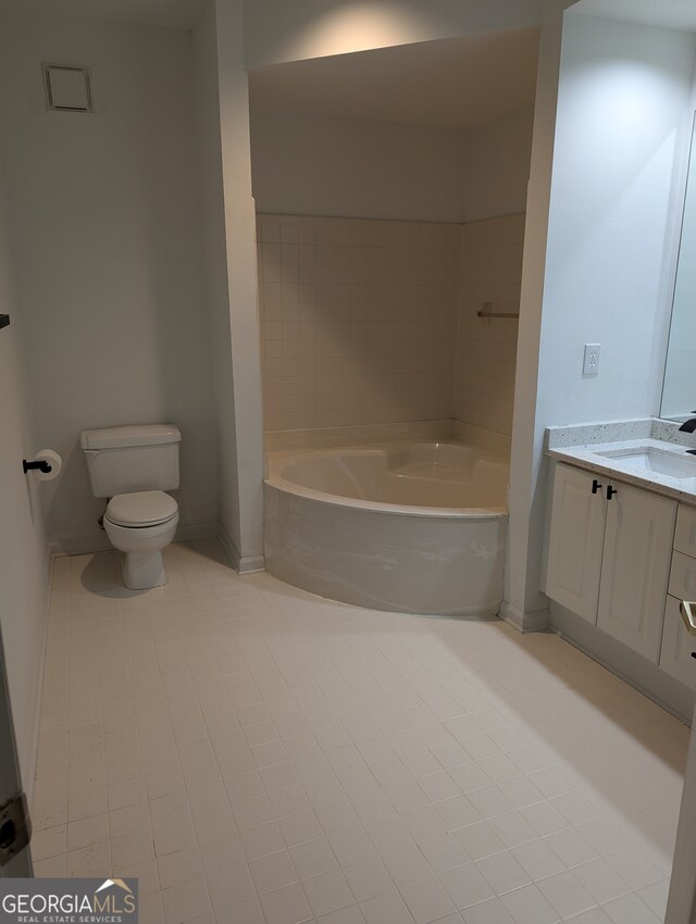 bathroom featuring tile patterned floors, a bathtub, toilet, and vanity