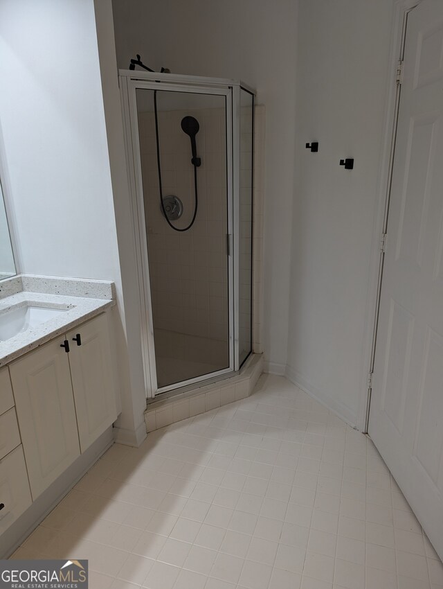 bathroom with tile patterned flooring, vanity, and a shower with shower door