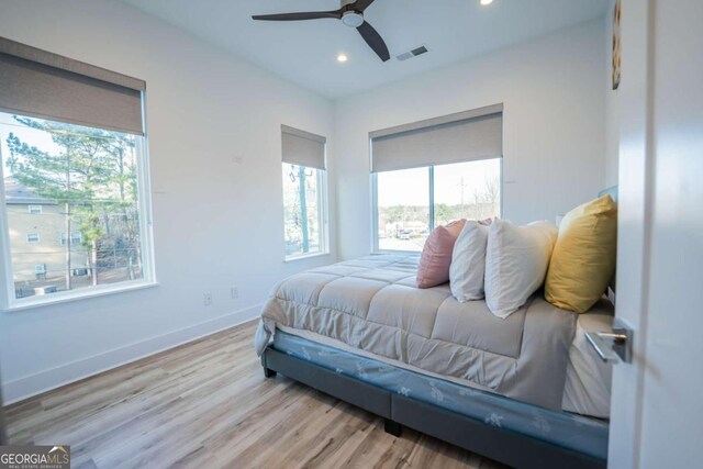 bedroom featuring multiple windows, light wood-type flooring, and ceiling fan