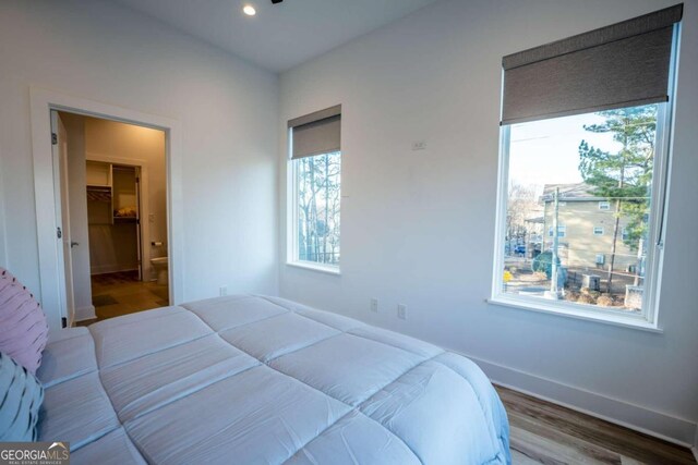 bedroom with wood-type flooring and multiple windows