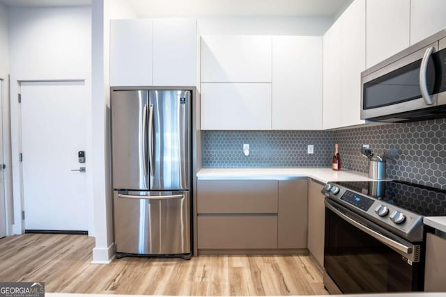 kitchen featuring light hardwood / wood-style flooring, stainless steel appliances, and white cabinets