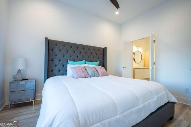 bedroom featuring ceiling fan, ensuite bath, and hardwood / wood-style floors