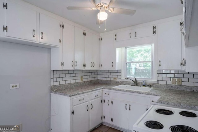 kitchen featuring white range, sink, white cabinets, and tasteful backsplash