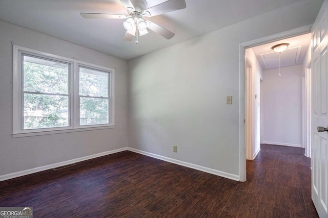 empty room with ceiling fan and dark hardwood / wood-style flooring