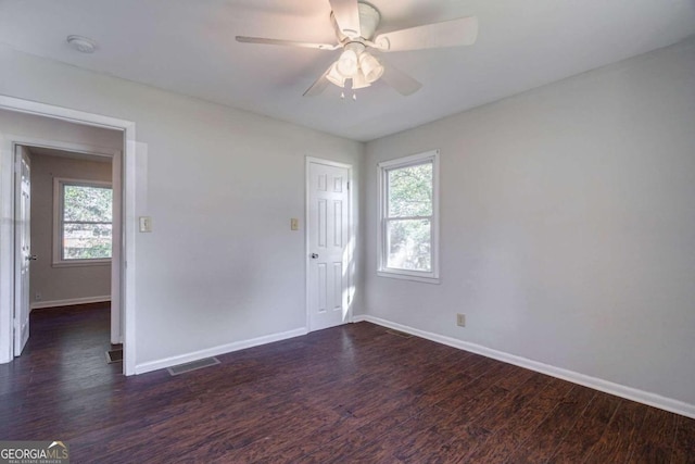 spare room with dark wood-type flooring and ceiling fan