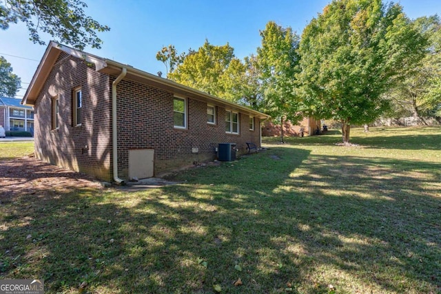 rear view of property featuring central AC unit and a lawn