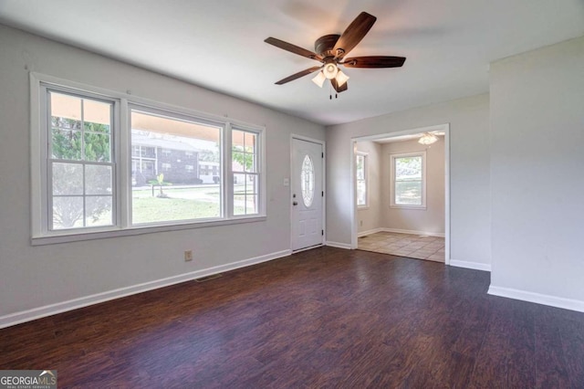 foyer entrance with dark hardwood / wood-style flooring, ceiling fan, and a wealth of natural light