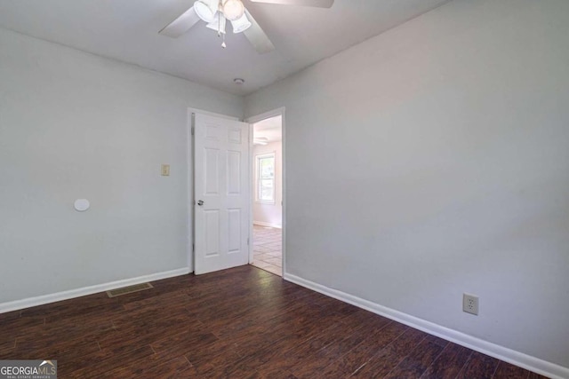 empty room featuring dark wood-type flooring and ceiling fan