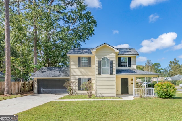 view of front of property featuring a front yard, a garage, and covered porch