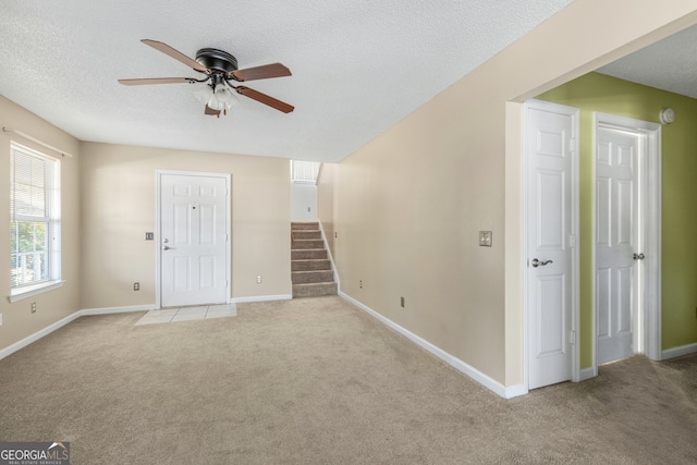 interior space with ceiling fan and a textured ceiling