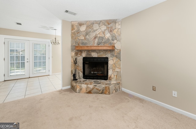 unfurnished living room with carpet, a fireplace, and french doors