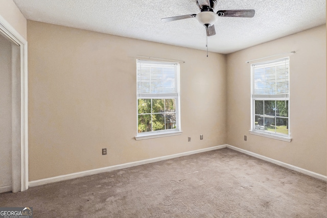 spare room featuring light carpet, plenty of natural light, and ceiling fan