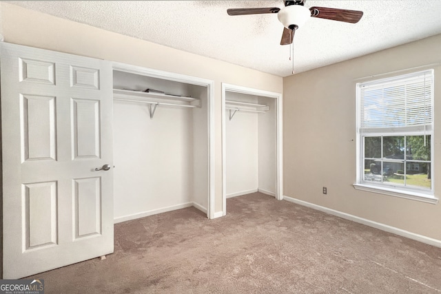 unfurnished bedroom featuring light carpet, a textured ceiling, and ceiling fan