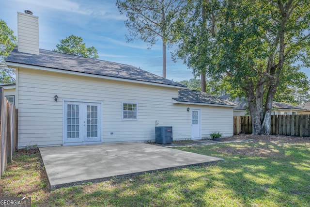 rear view of house featuring a patio area, cooling unit, and a lawn