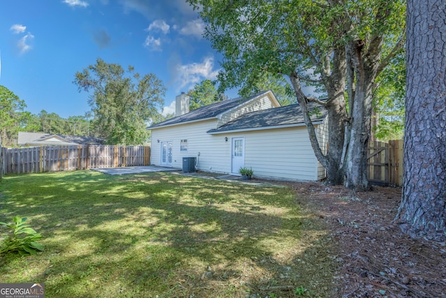 rear view of house featuring a patio area, a yard, and central AC unit