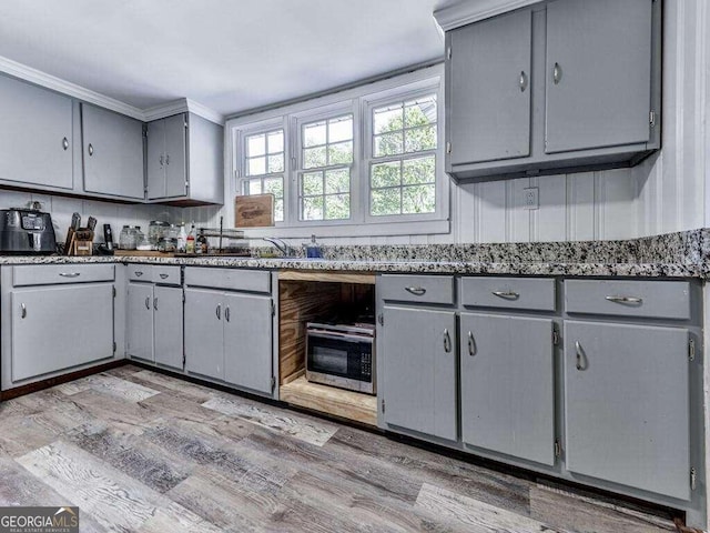 kitchen featuring ornamental molding, sink, gray cabinetry, and light wood-type flooring