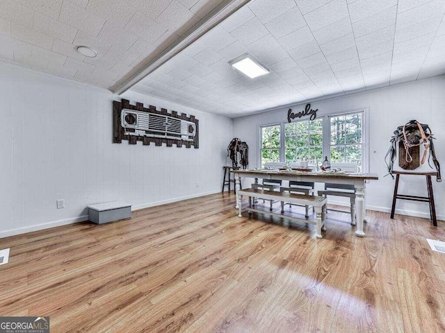 dining area featuring light hardwood / wood-style floors and wood walls