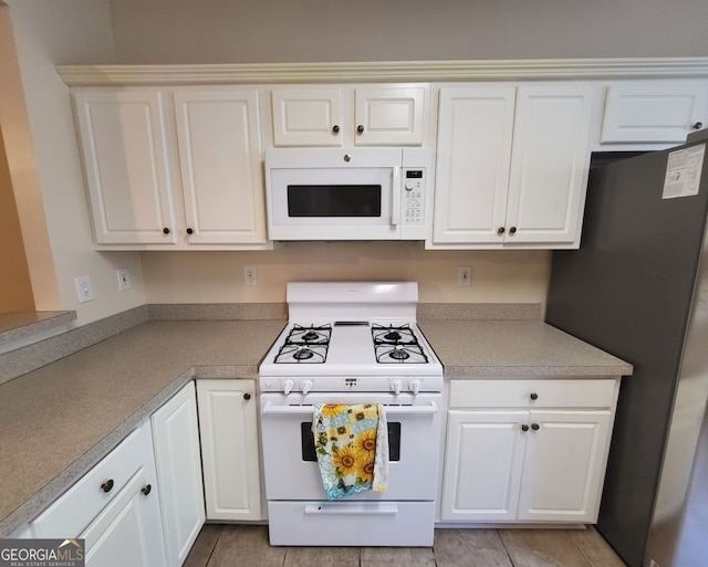 kitchen with white cabinetry and white appliances