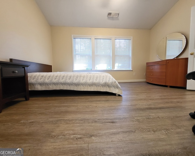 bedroom featuring lofted ceiling and hardwood / wood-style flooring