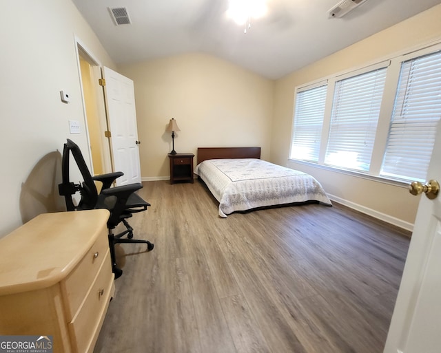 bedroom with ceiling fan, lofted ceiling, and hardwood / wood-style floors