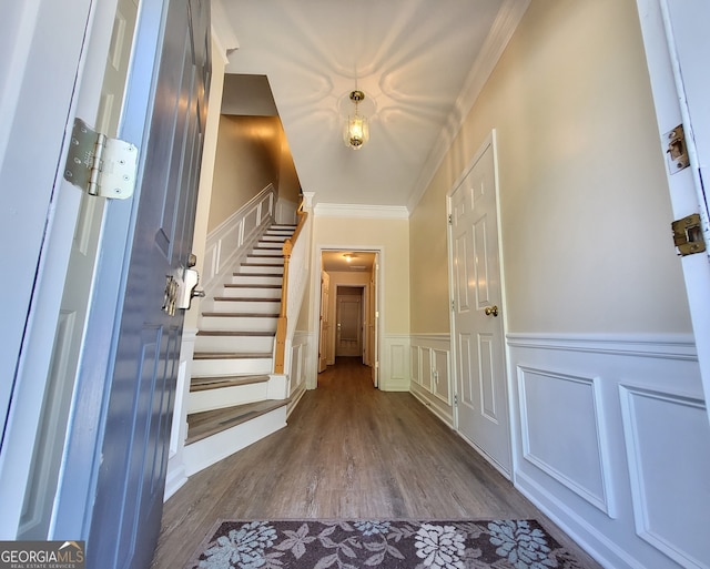 entryway with ornamental molding and wood-type flooring