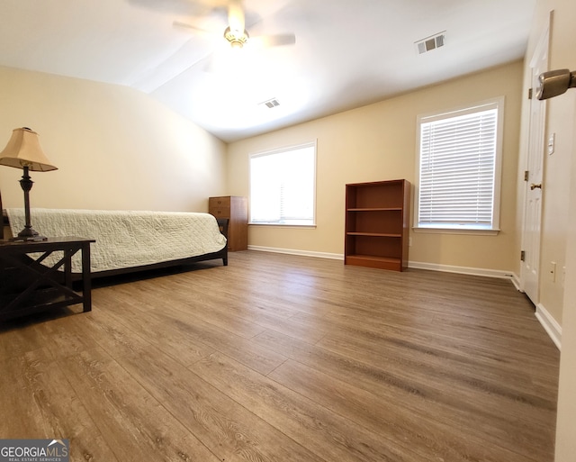 bedroom with wood-type flooring, vaulted ceiling, and ceiling fan