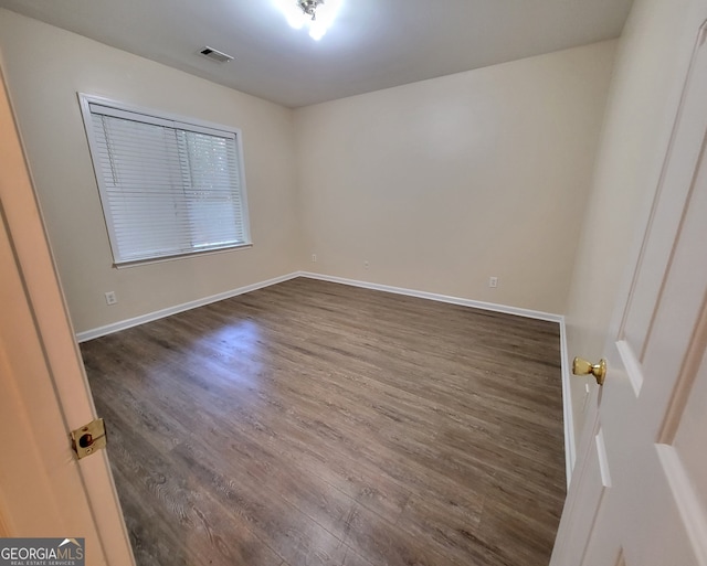 spare room with dark hardwood / wood-style flooring