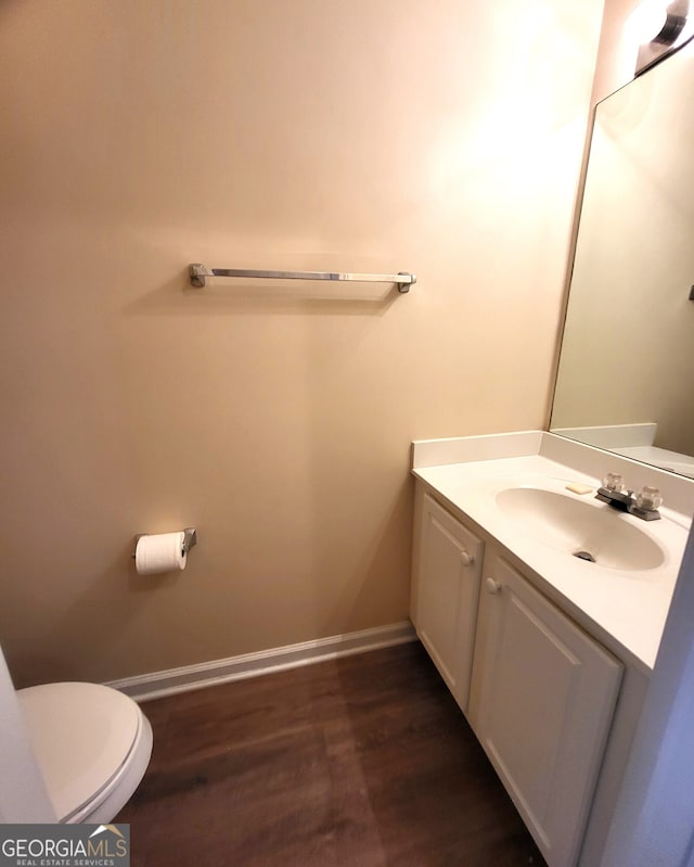 bathroom with vanity, wood-type flooring, and toilet