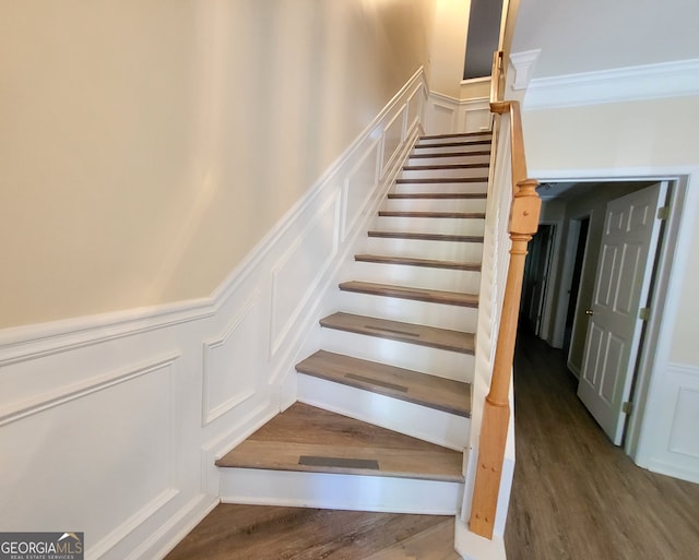 staircase featuring crown molding and wood-type flooring