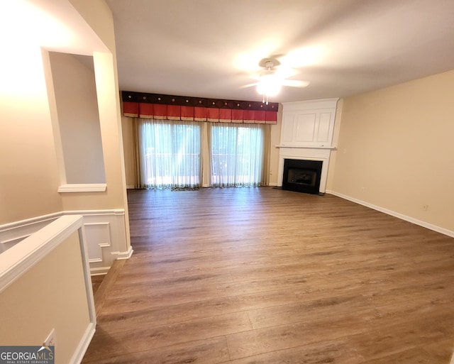 unfurnished living room with hardwood / wood-style flooring, a fireplace, and ceiling fan