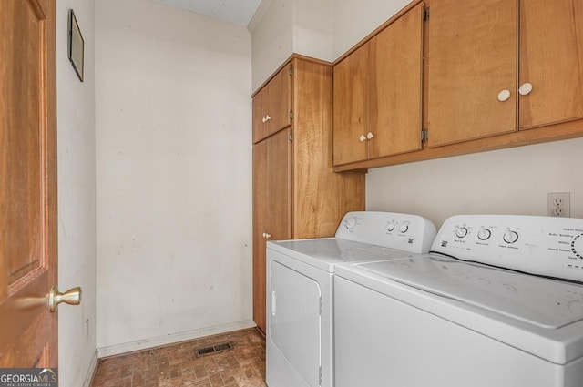 washroom with cabinets and washing machine and clothes dryer