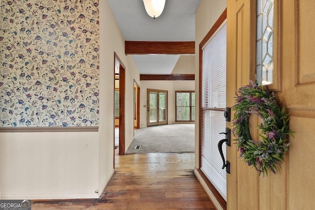 corridor with beamed ceiling and wood-type flooring