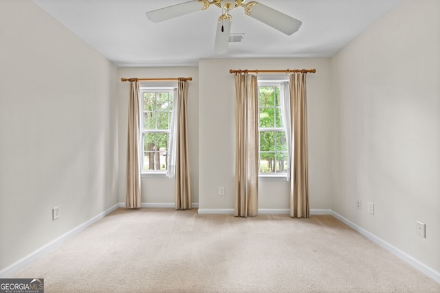 carpeted empty room with plenty of natural light and ceiling fan