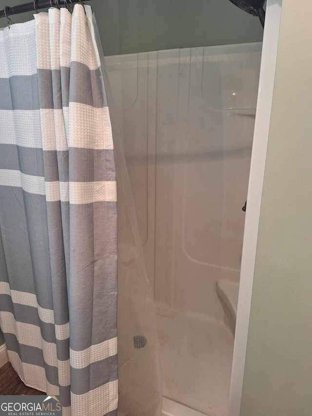 bathroom with hardwood / wood-style flooring and curtained shower