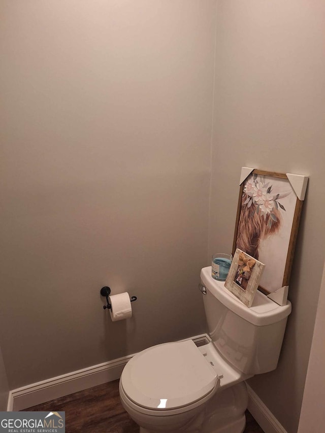 bathroom with hardwood / wood-style flooring and toilet