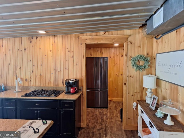 kitchen featuring dark hardwood / wood-style floors, black refrigerator, and stainless steel gas cooktop