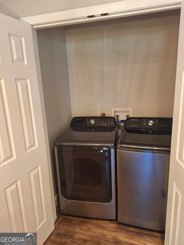 clothes washing area with dark hardwood / wood-style flooring and separate washer and dryer