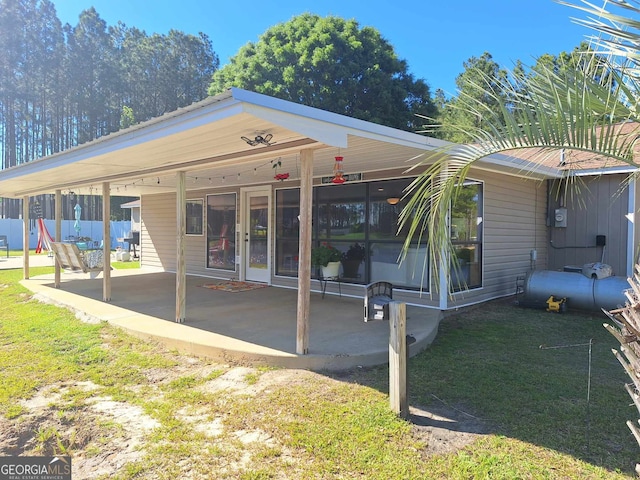 view of front of property with a patio, a sunroom, and a front lawn