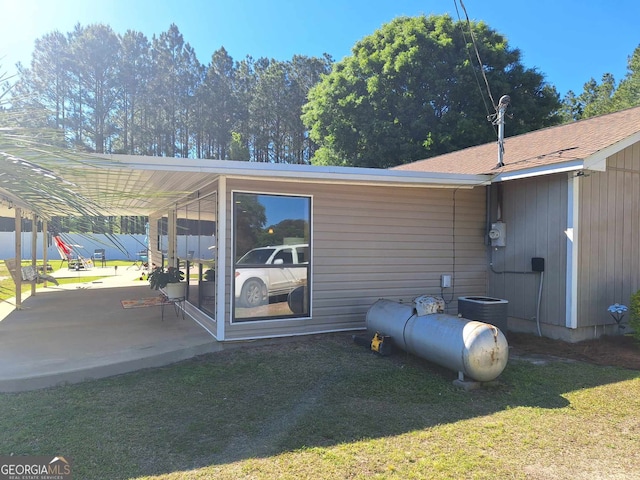 view of side of home featuring a patio, cooling unit, and a lawn