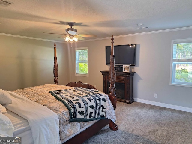 carpeted bedroom with ceiling fan, crown molding, and a textured ceiling