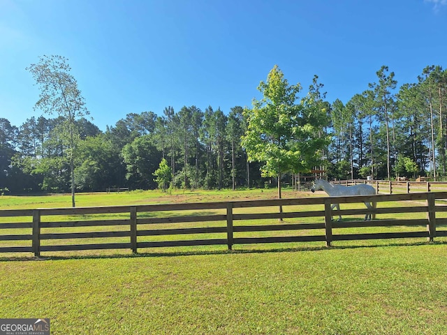 view of gate featuring a rural view and a lawn