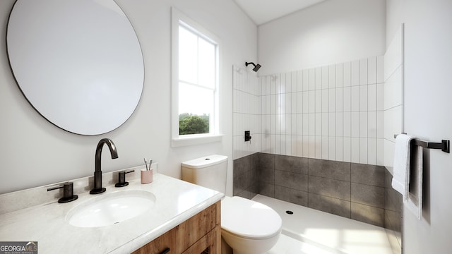 bathroom with vanity, toilet, and tiled shower