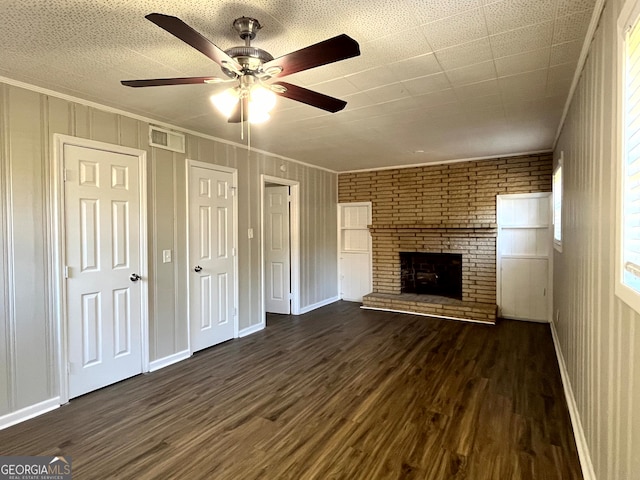 unfurnished living room with crown molding, dark hardwood / wood-style floors, a fireplace, and ceiling fan