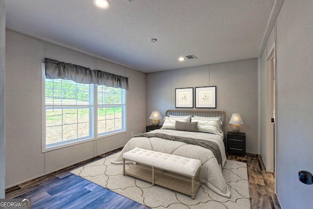 bedroom with wood-type flooring and a textured ceiling